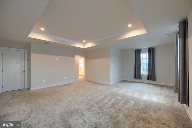 carpeted empty room with a tray ceiling