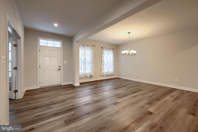 foyer with an inviting chandelier and dark hardwood / wood-style flooring