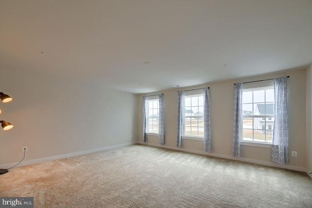 unfurnished room featuring plenty of natural light and carpet flooring