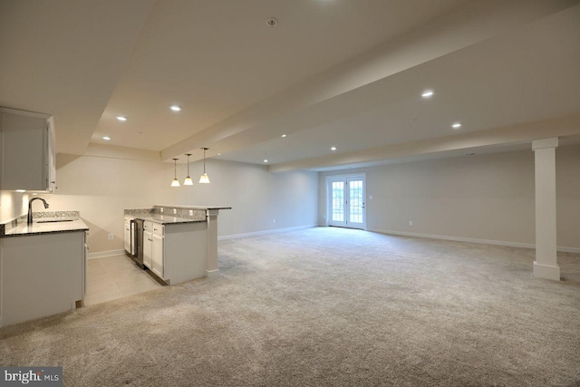 interior space with decorative light fixtures, sink, white cabinets, and french doors