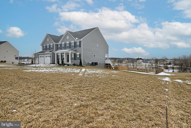 back of house featuring a garage, central AC unit, and a yard