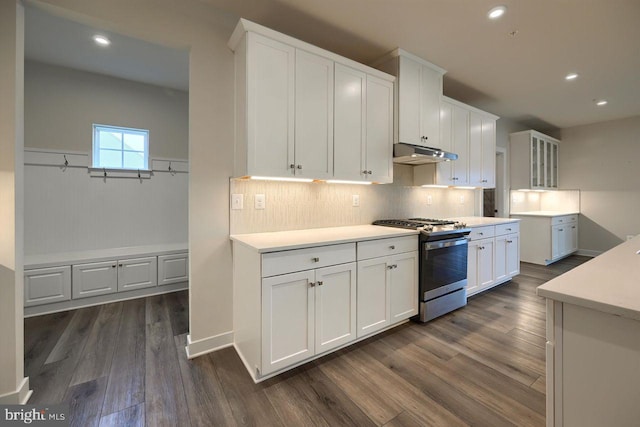 kitchen featuring backsplash, dark wood-type flooring, gas range, and white cabinetry