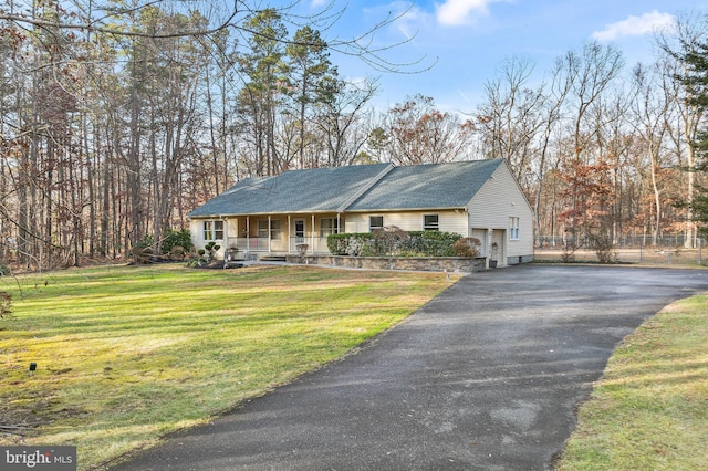 view of front of home featuring a front lawn, covered porch, and a garage