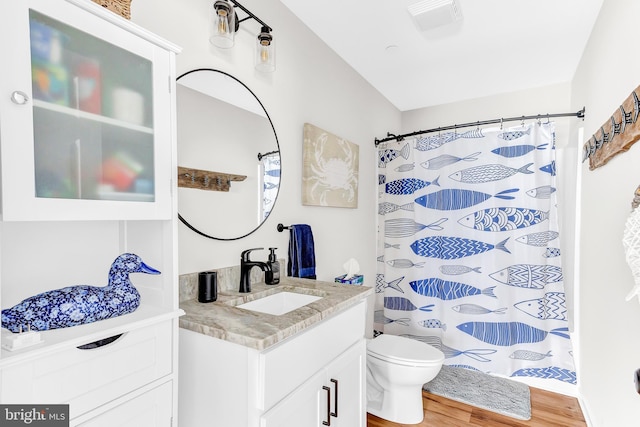 bathroom featuring vanity, hardwood / wood-style flooring, a shower with curtain, and toilet