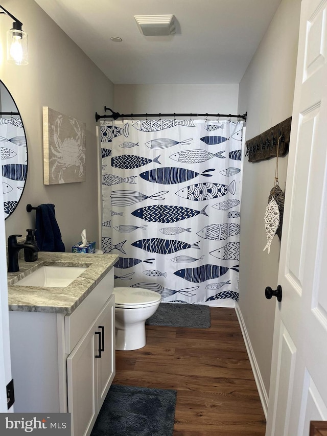 bathroom with vanity, curtained shower, wood-type flooring, and toilet