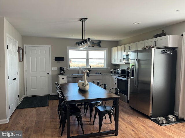 dining area with sink and wood-type flooring