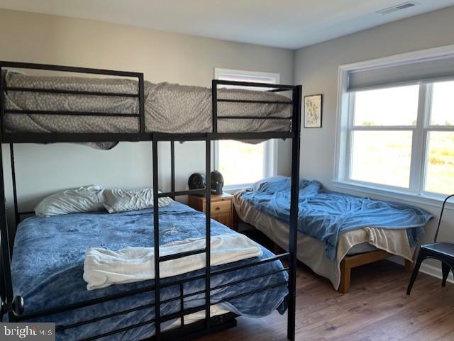 bedroom with hardwood / wood-style flooring and multiple windows