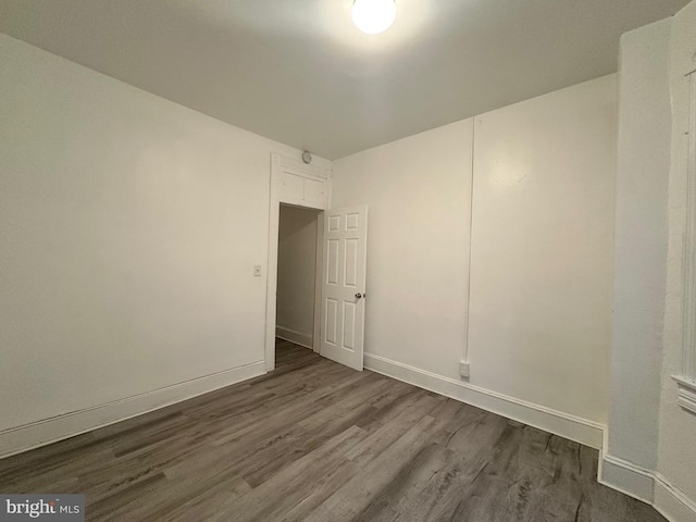 empty room with dark hardwood / wood-style flooring