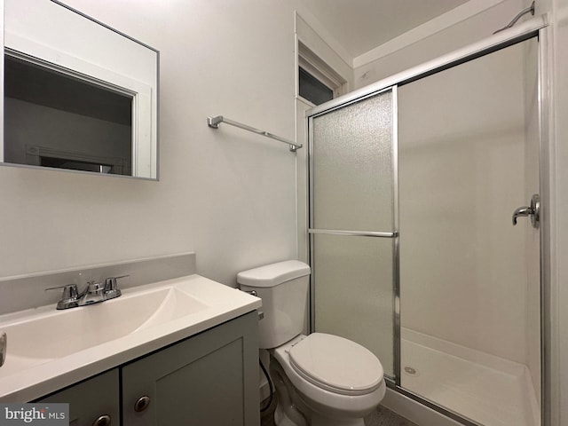 bathroom with toilet, a shower with door, and vanity