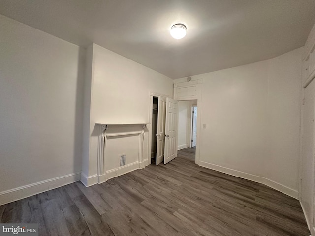 unfurnished room with dark hardwood / wood-style flooring