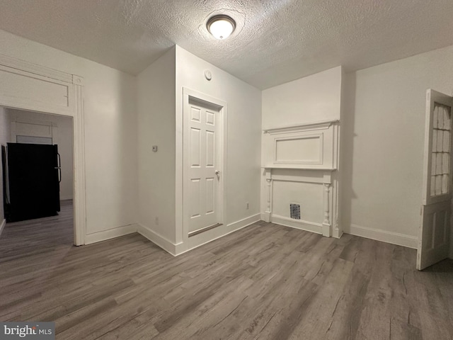 bonus room with a textured ceiling and hardwood / wood-style flooring