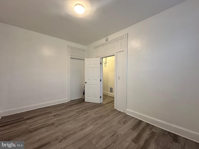 unfurnished bedroom featuring dark hardwood / wood-style flooring