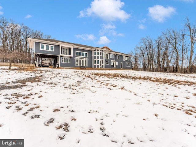 view of snow covered back of property