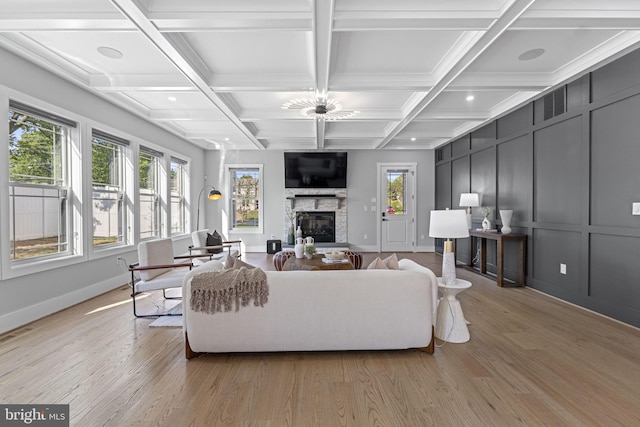 living room featuring coffered ceiling, beam ceiling, and light wood-type flooring