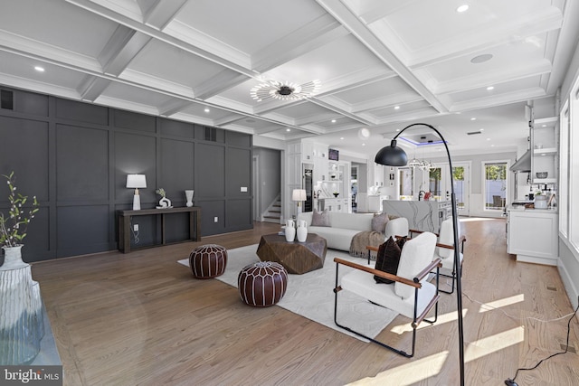 living room featuring crown molding, coffered ceiling, beam ceiling, and light hardwood / wood-style flooring