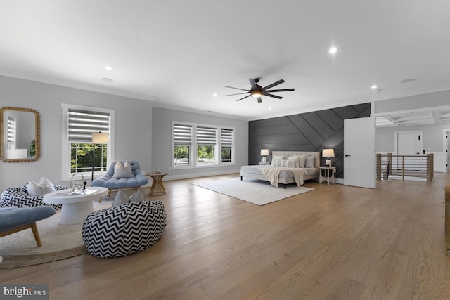 bedroom with ceiling fan, ornamental molding, and light wood-type flooring