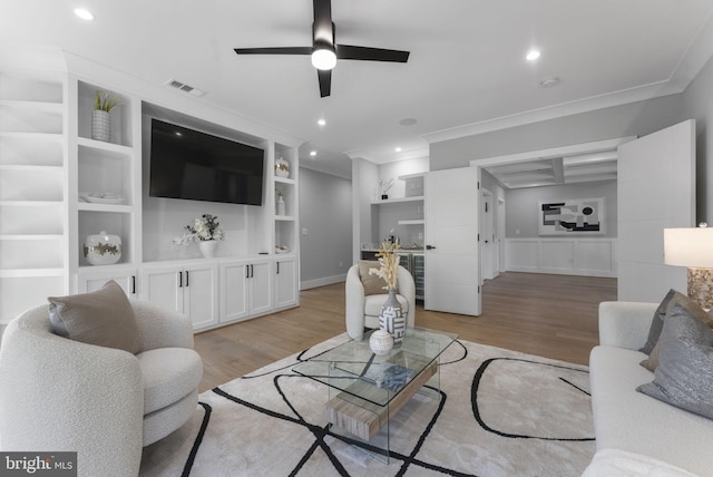 living room with ornamental molding, ceiling fan, built in features, and light wood-type flooring