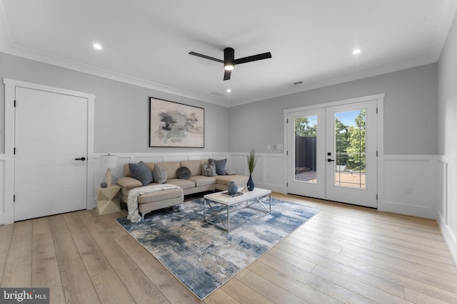 living room featuring french doors, ceiling fan, ornamental molding, and light wood-type flooring