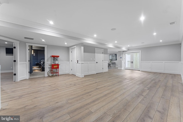 unfurnished living room with ornamental molding, light hardwood / wood-style floors, and french doors