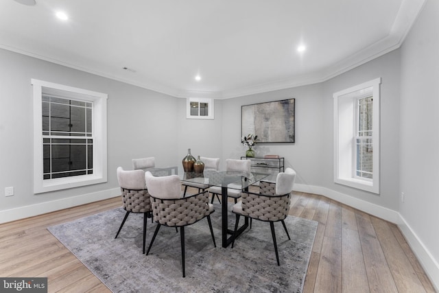 dining room with ornamental molding and light hardwood / wood-style floors