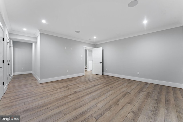 unfurnished room with ornamental molding, a barn door, and light hardwood / wood-style flooring