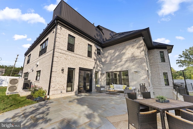 back of house featuring an outdoor living space and a patio