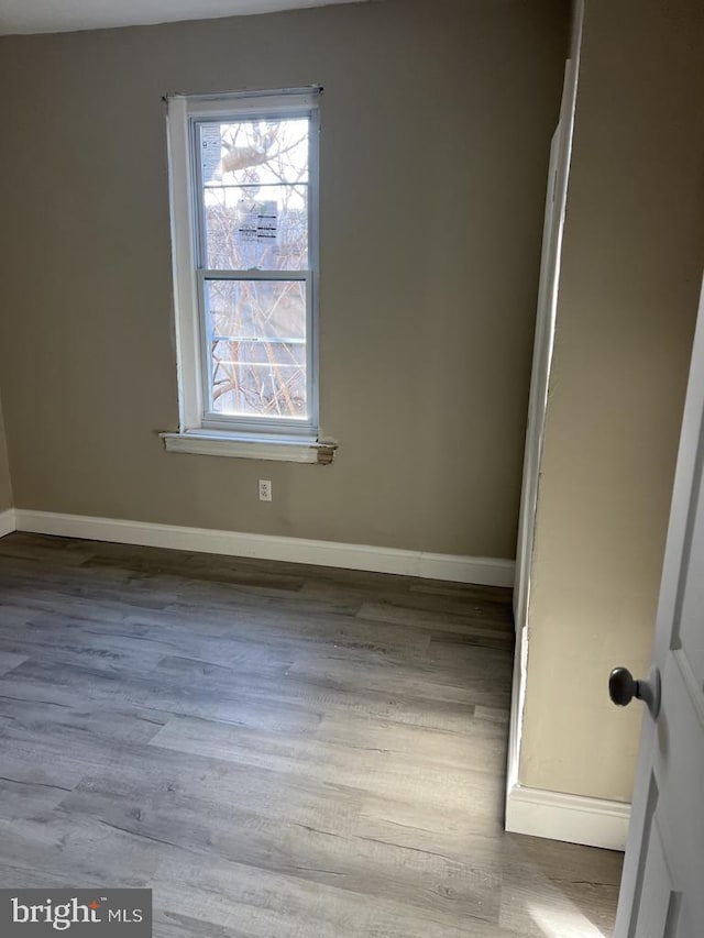 unfurnished room with wood-type flooring