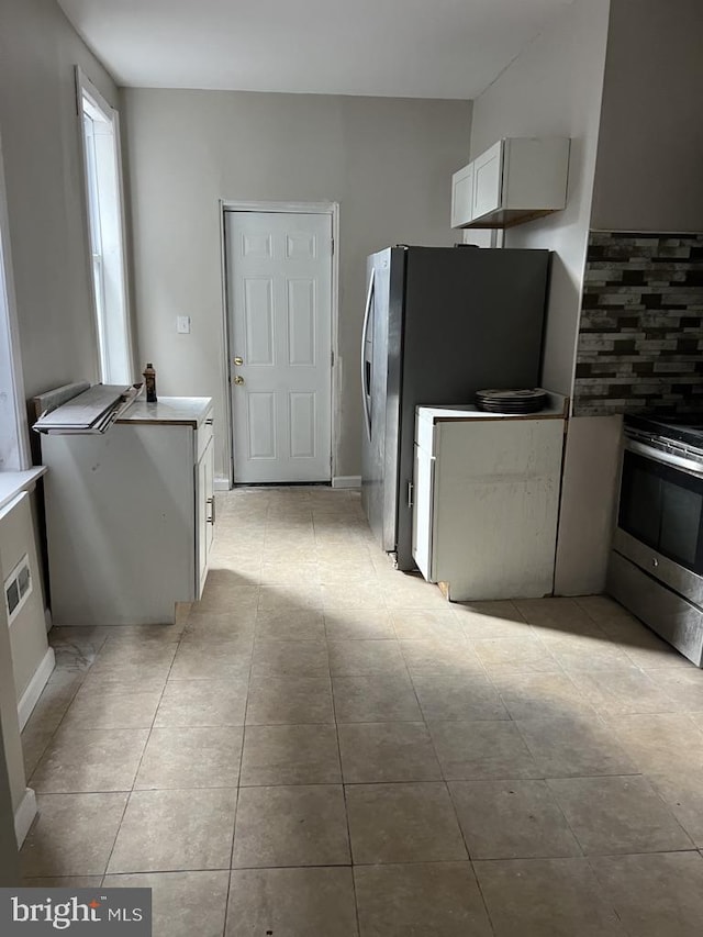 kitchen featuring tasteful backsplash, white cabinets, and appliances with stainless steel finishes