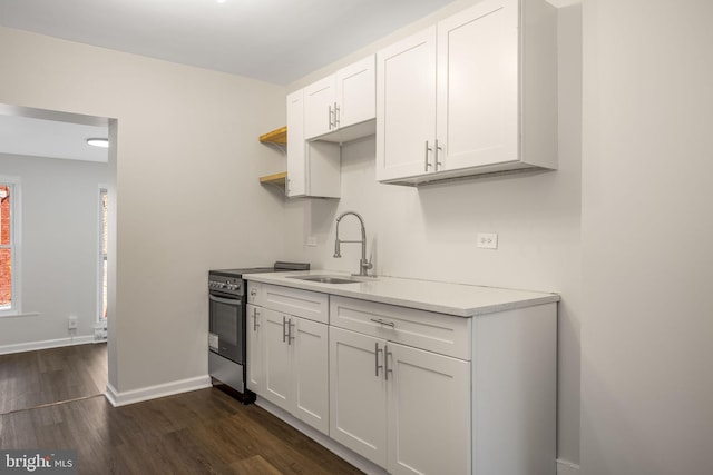 kitchen with white cabinets, dark hardwood / wood-style flooring, sink, and stainless steel electric stove