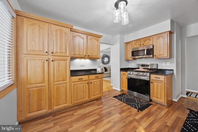 kitchen with appliances with stainless steel finishes, light brown cabinets, and light wood-type flooring