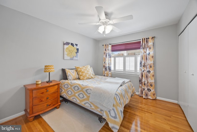 bedroom with light hardwood / wood-style floors, ceiling fan, and a closet