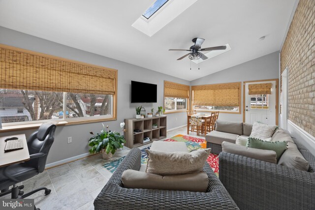 living room featuring lofted ceiling with skylight and ceiling fan