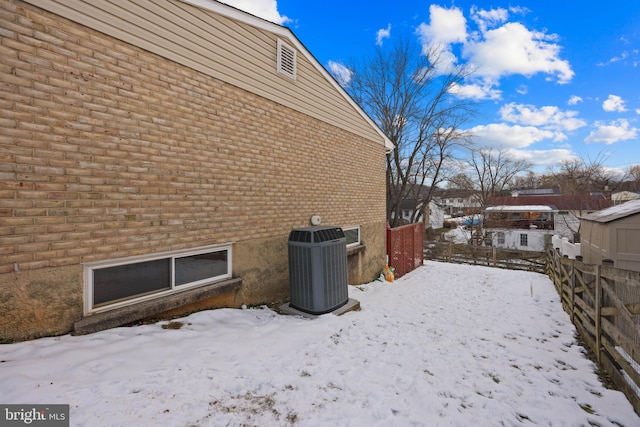 view of snowy exterior with central AC unit