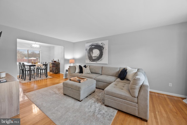 living room with wood-type flooring and an inviting chandelier