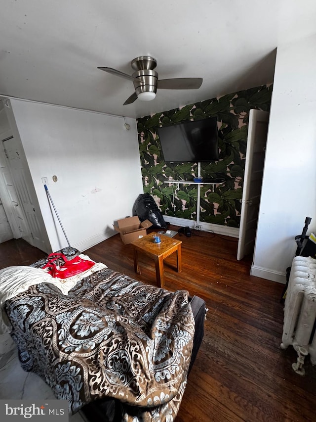 interior space with ceiling fan, radiator, and dark hardwood / wood-style flooring