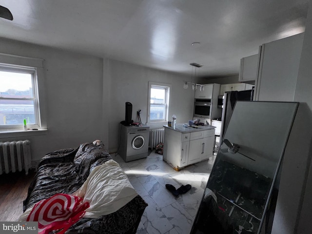 kitchen featuring a wealth of natural light, stainless steel appliances, and radiator heating unit