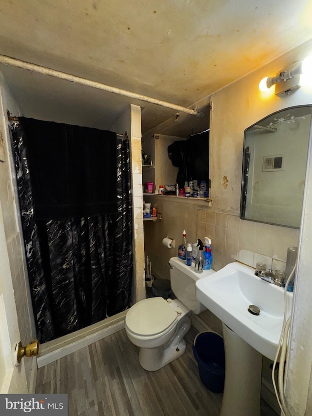 bathroom with toilet, decorative backsplash, hardwood / wood-style floors, and walk in shower