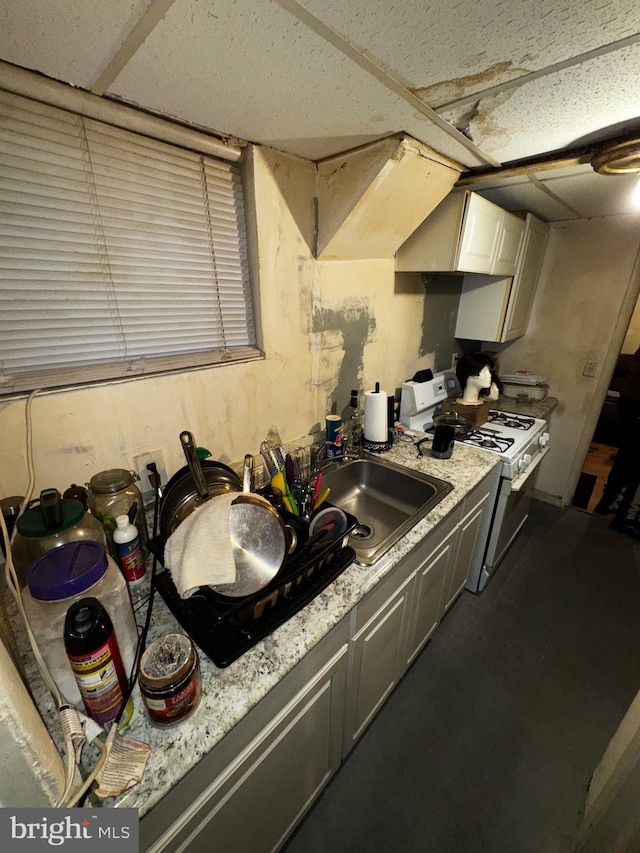 kitchen with custom exhaust hood, sink, white gas range oven, and light stone countertops