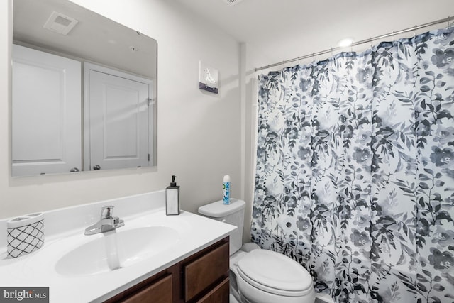 bathroom featuring toilet, vanity, and curtained shower