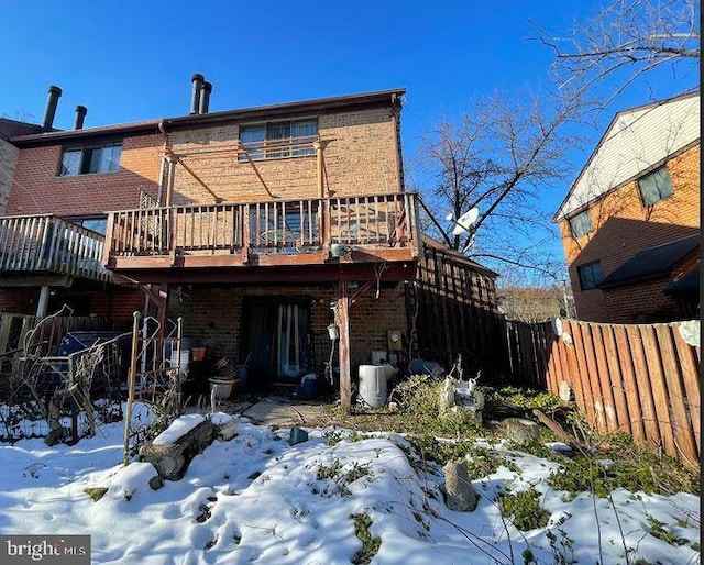 snow covered rear of property featuring a wooden deck