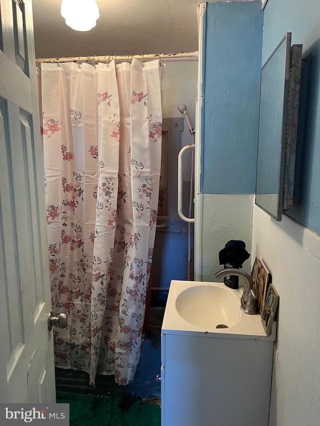 bathroom featuring curtained shower and vanity