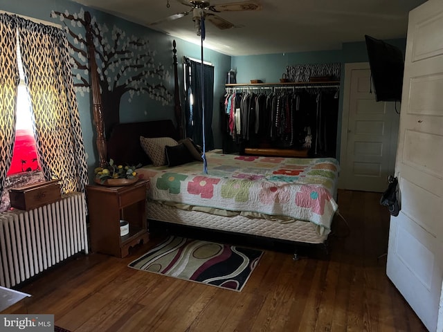 bedroom featuring radiator, a closet, and wood finished floors