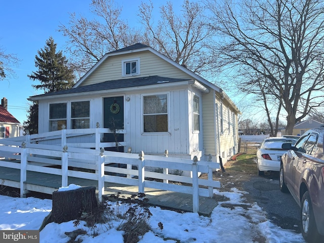 view of front of house featuring a fenced front yard and roof with shingles