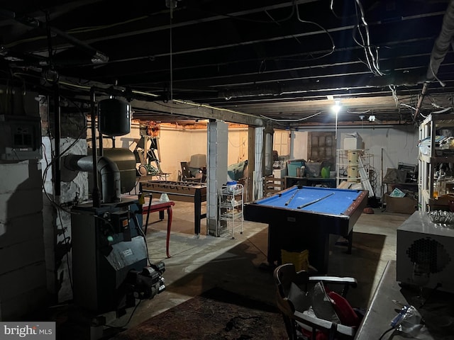 unfinished below grade area featuring a heating unit and pool table