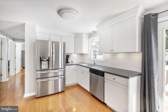 kitchen featuring sink, white cabinetry, appliances with stainless steel finishes, and tasteful backsplash