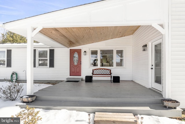 snow covered property entrance featuring a porch