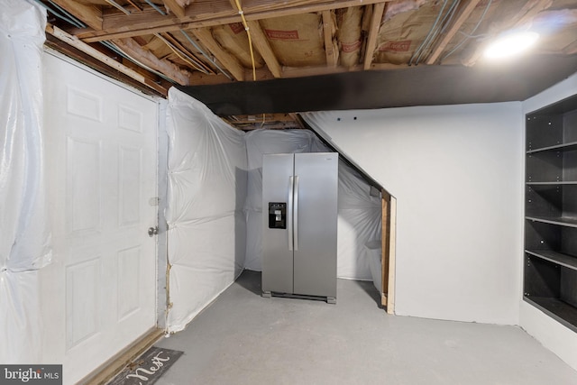 basement featuring stainless steel refrigerator with ice dispenser