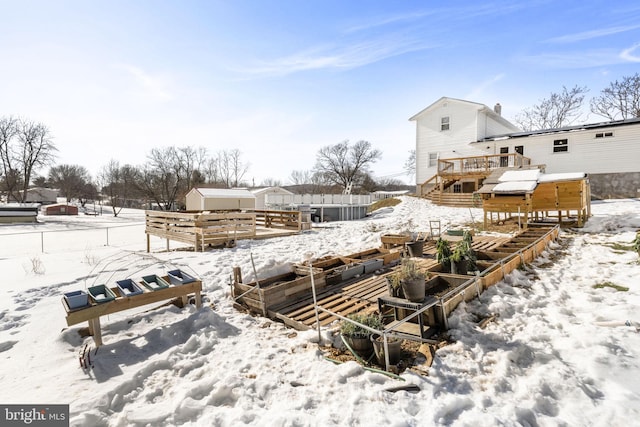 yard covered in snow featuring a deck