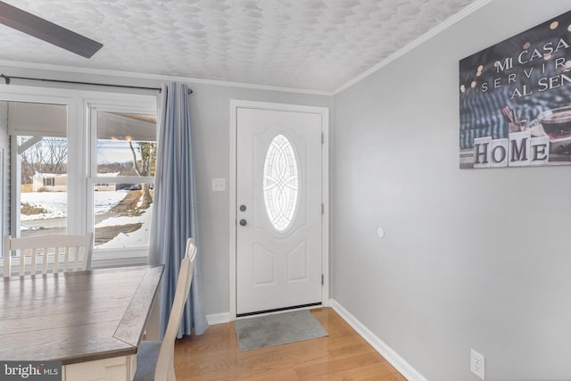 entrance foyer with wood-type flooring, crown molding, and a textured ceiling