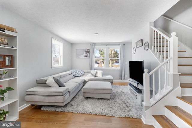 living room with a textured ceiling and hardwood / wood-style floors